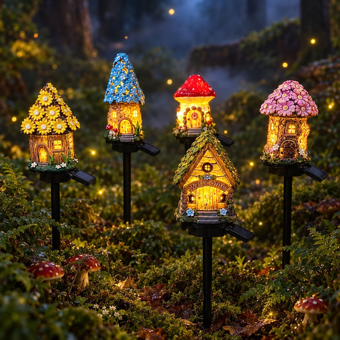 Fairy cottage solar garden stake lights in mushroom, sunflower and tree house styles glowing on a mossy forest floor at night